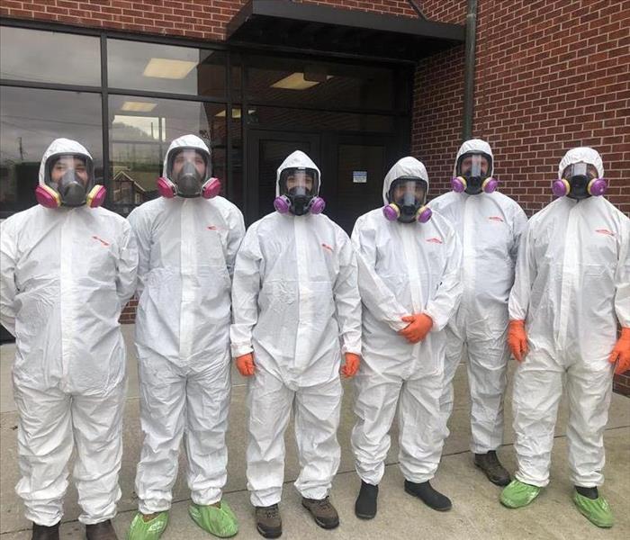 SERVPRO employees in hazmat suits cleaning 