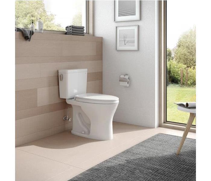 a clean bathroom with a grey rug and a white toilet