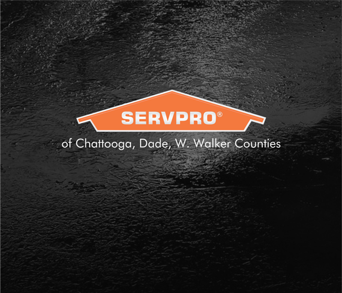 Black ice on a dark road with the SERVPRO logo on top of the black ice